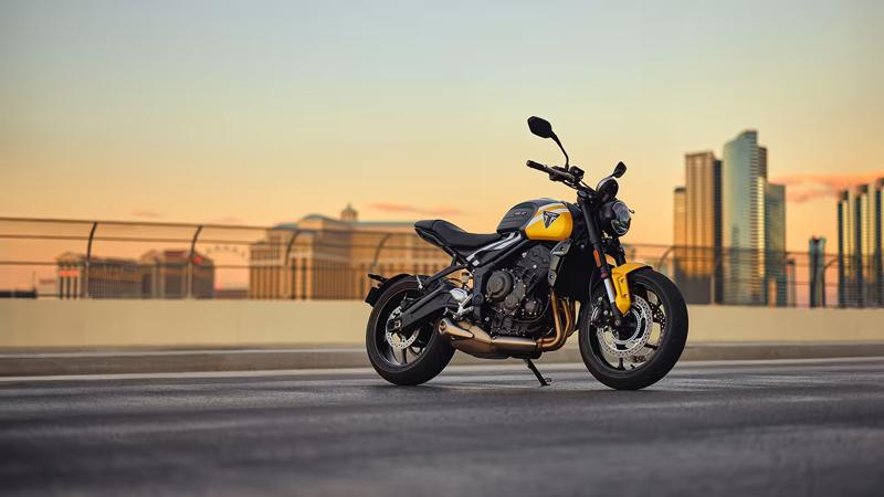 yellow and black bike sits on road in front of city skyline