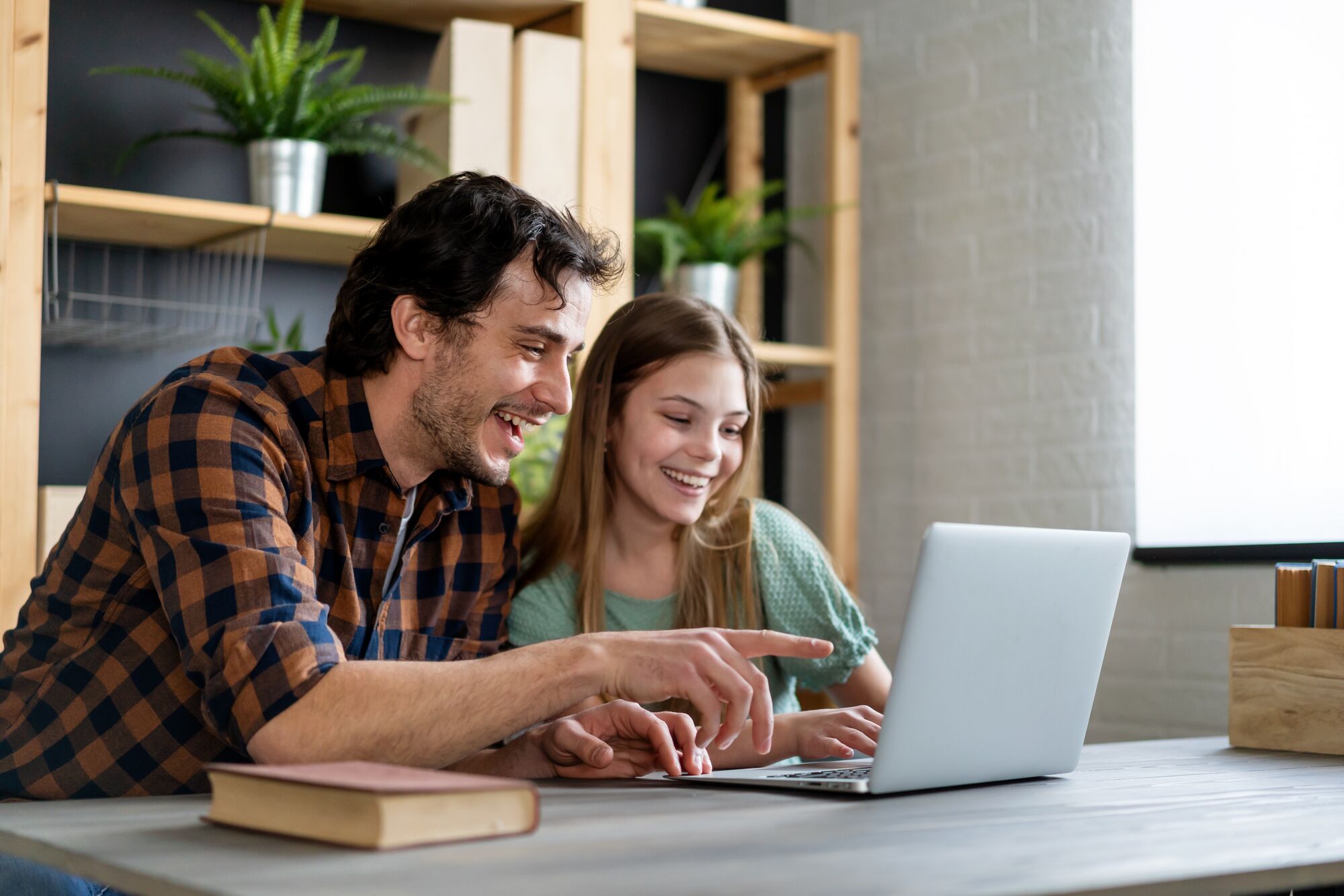 Father and teen daughter setting up laptop for schoolwork
