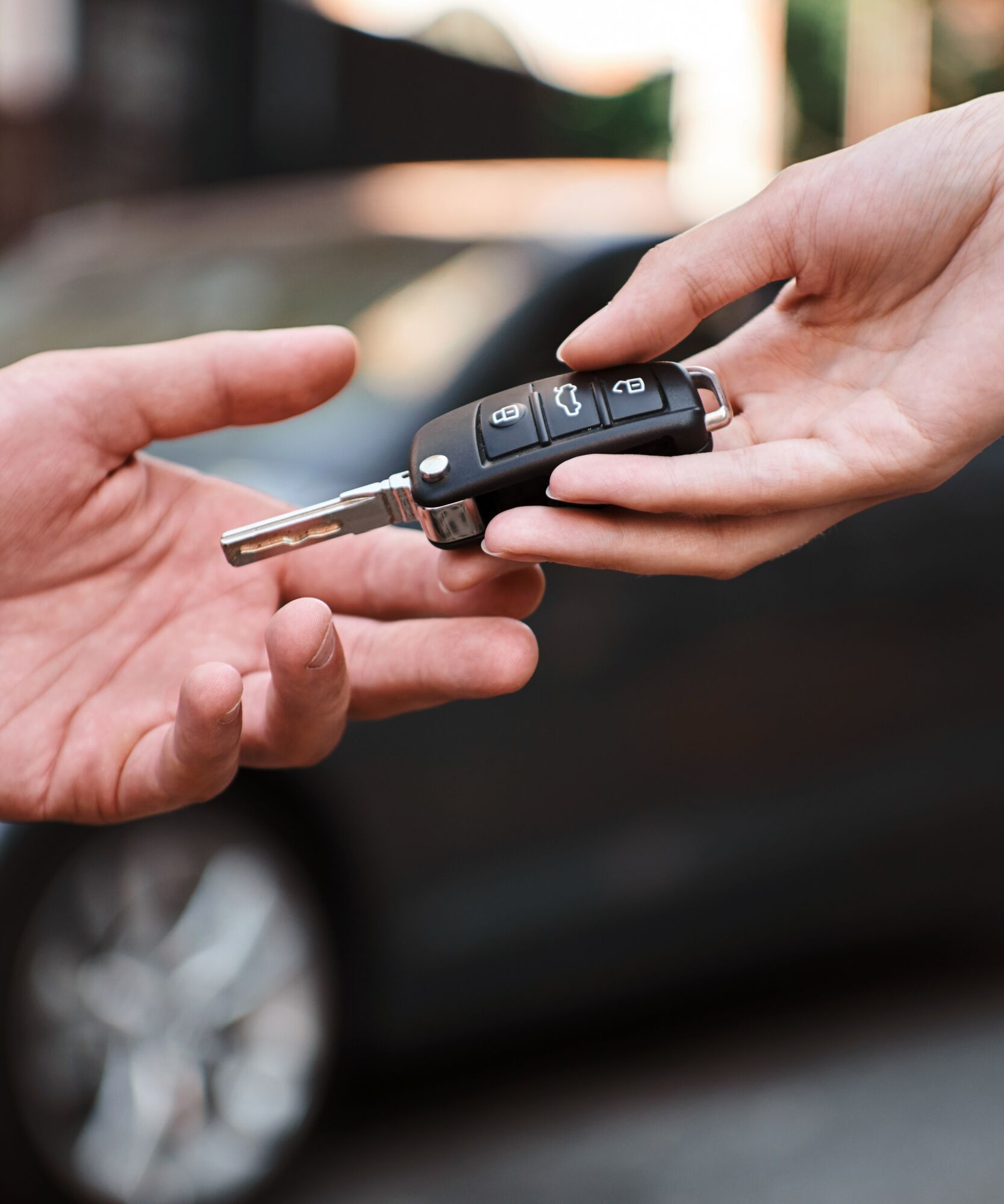 Car dealership.Young man receiving car key from saleswoman.