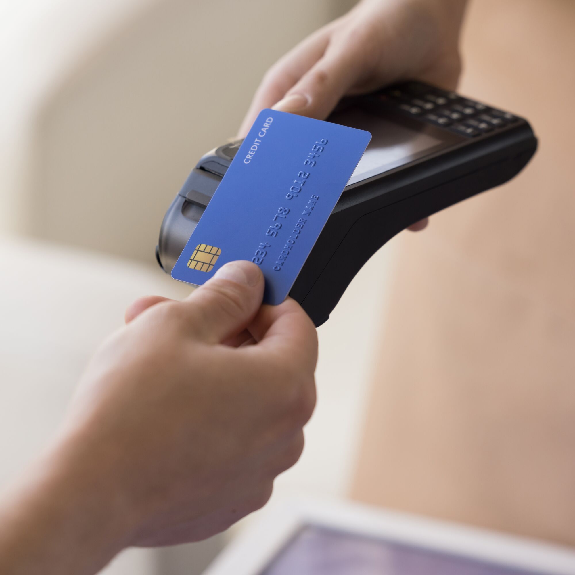 Hand of bank cardholder paying bill in cafe