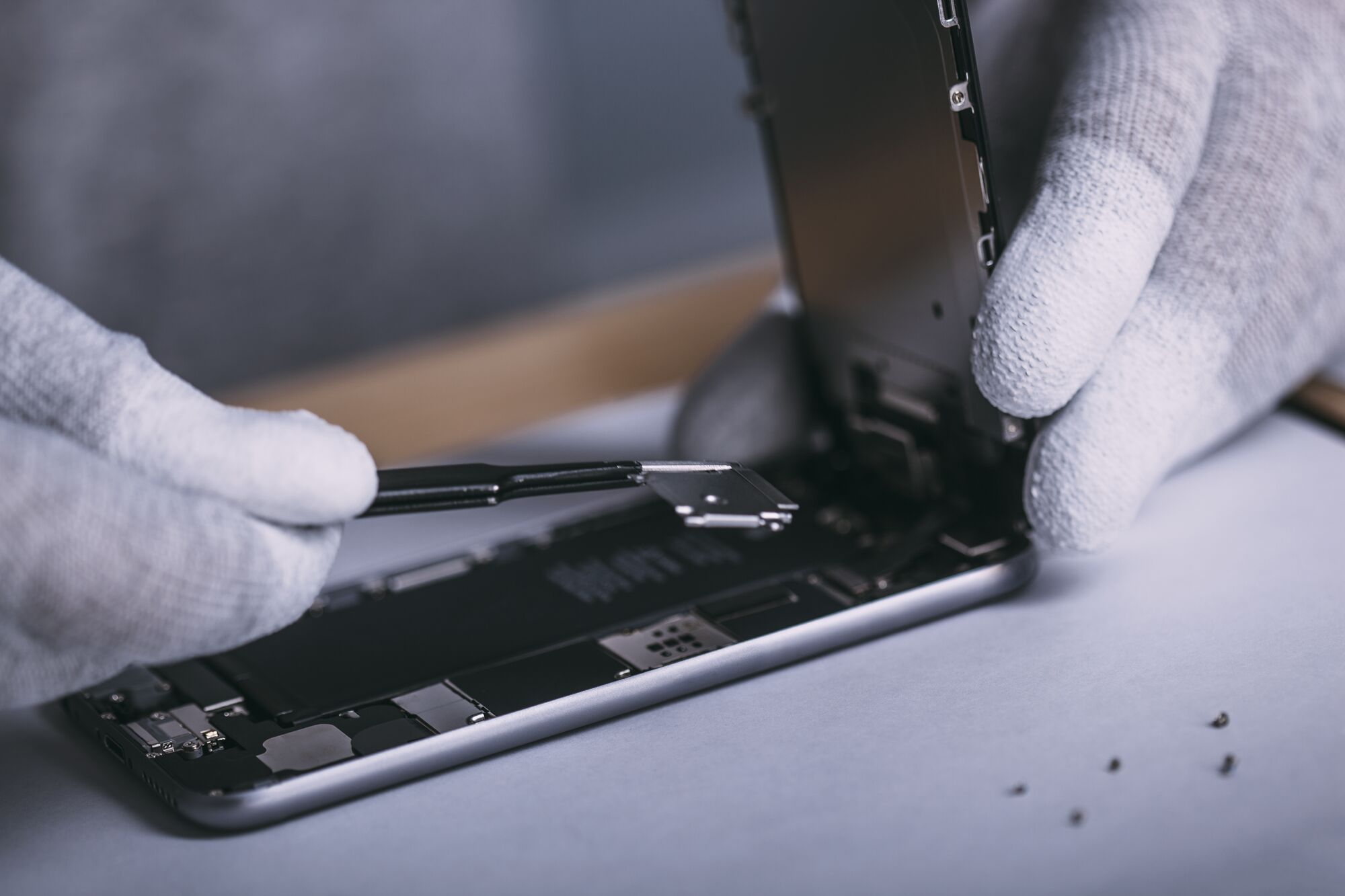 Detail image of male technician repairing smart phone at electronics store - stock photo