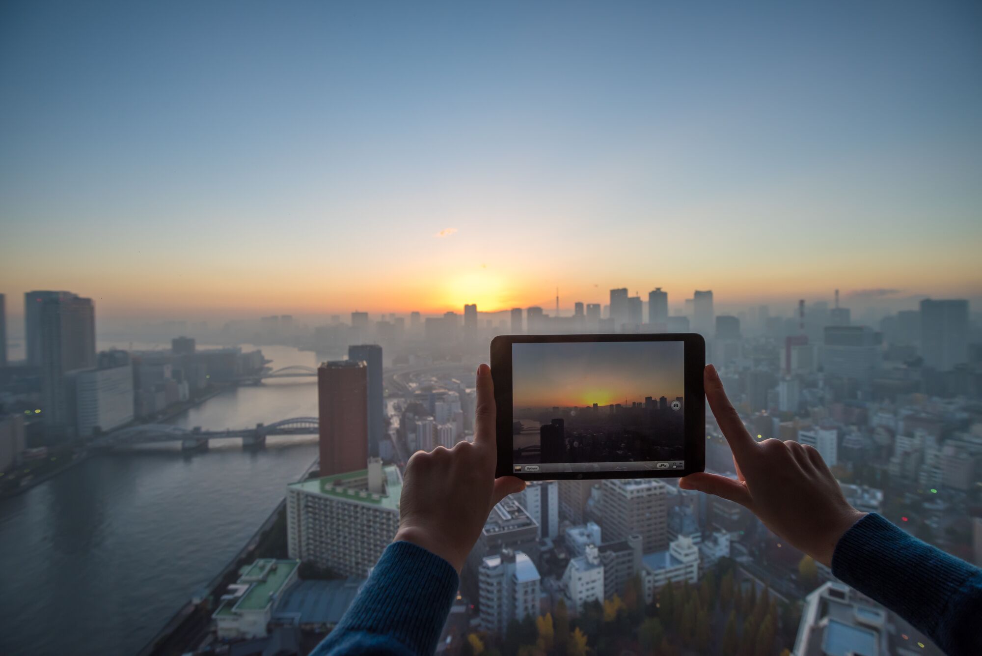Girl taking picture of Tokyo with tablet 