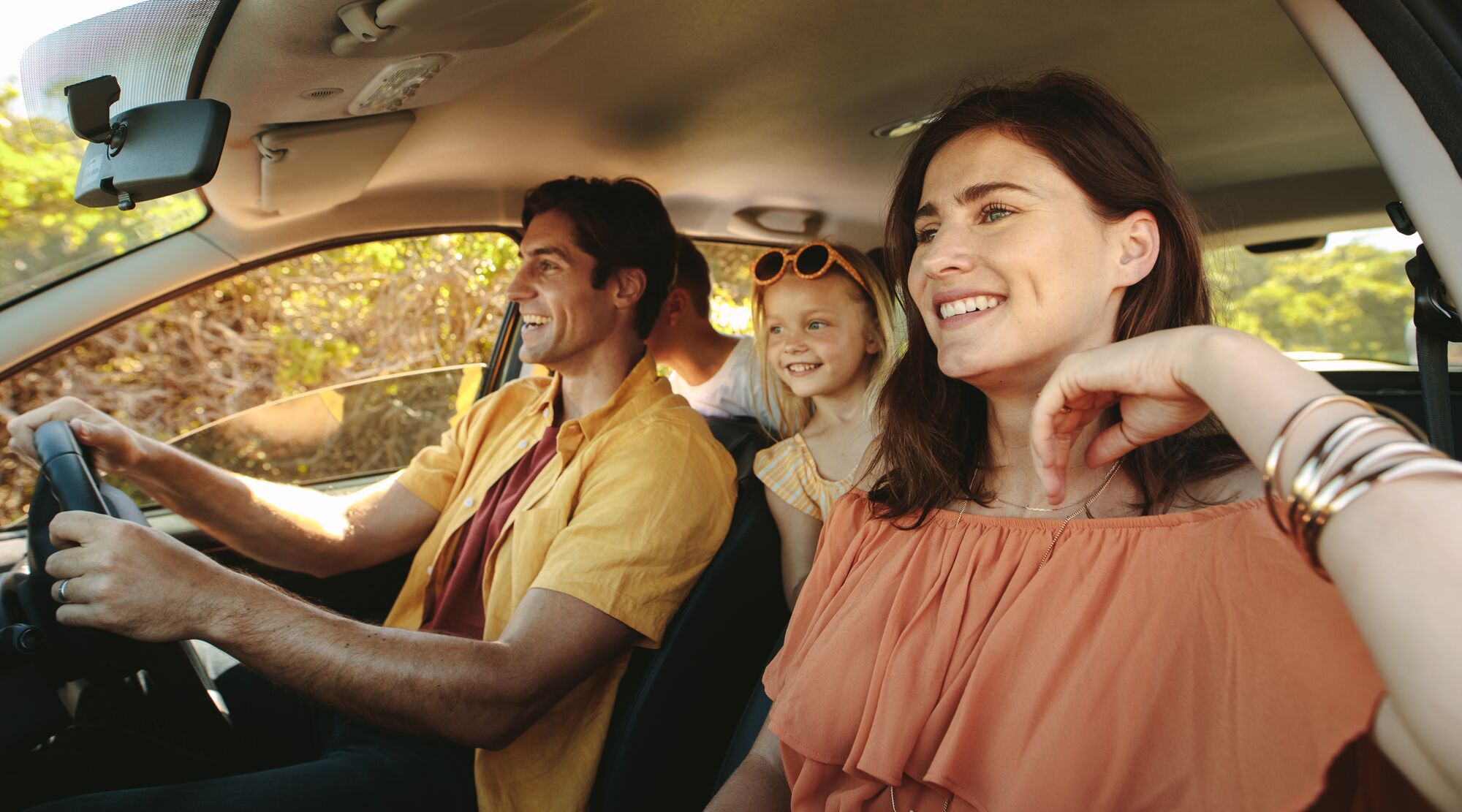 Family driving in a car on countryside road trip. Family with two children driving in a car.