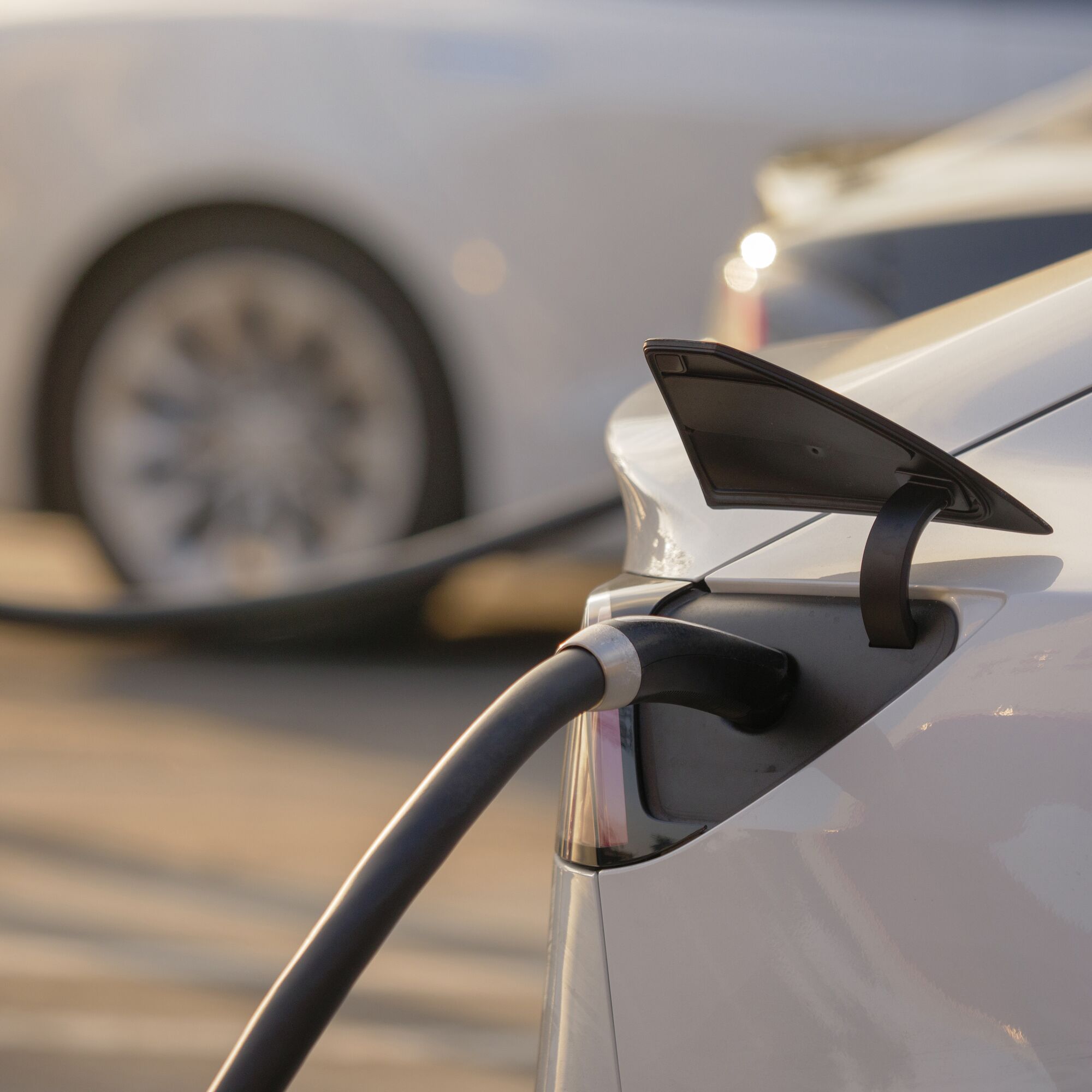 Electric cars charging at charging station outdoors at sunset.