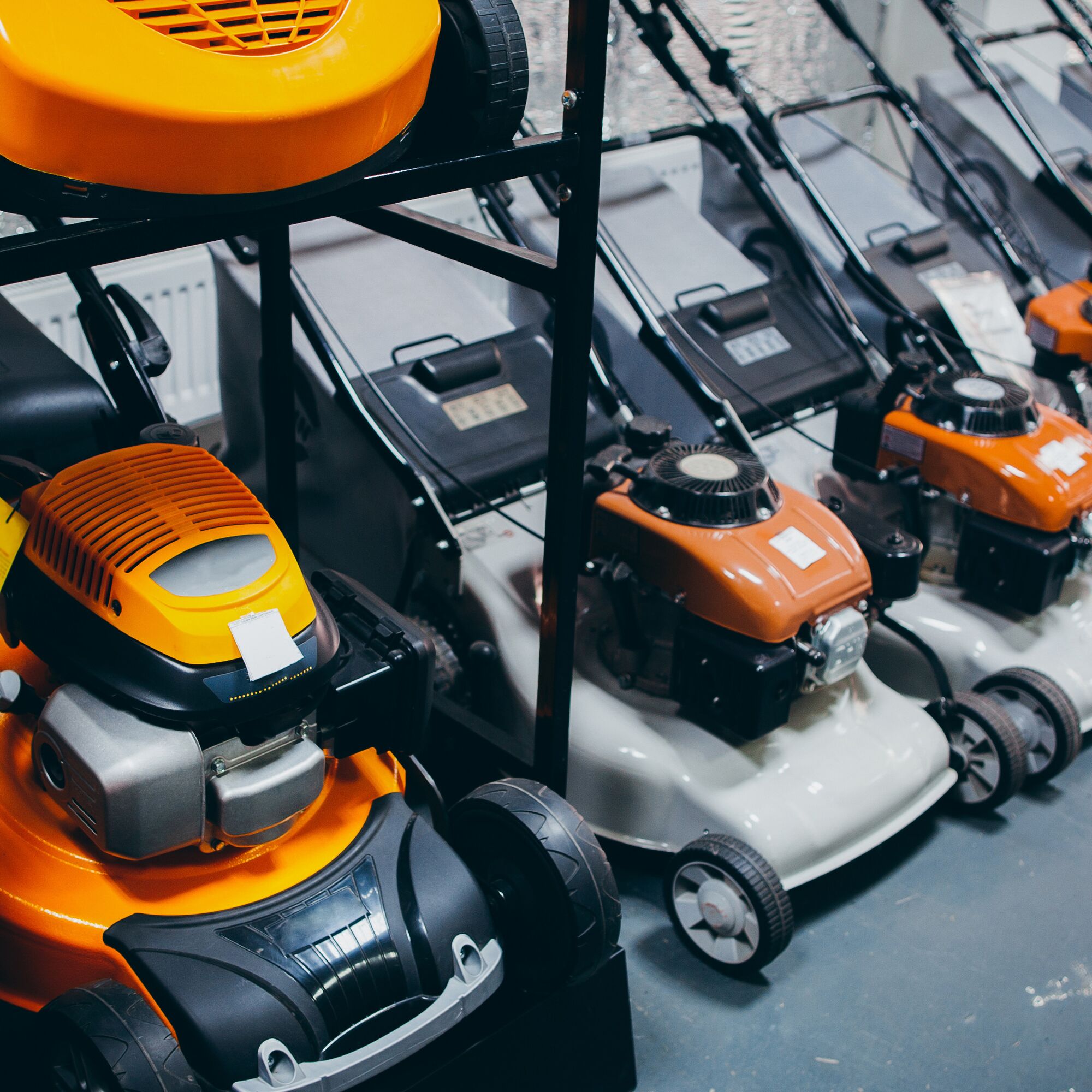 Outdoor power equipment. Home depot. Showcase of new powerful yellow gasoline lawn mower.