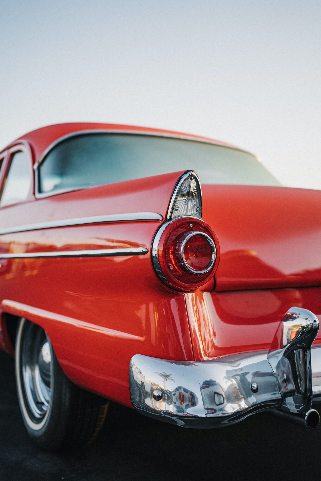 medium shot of black driver side taillight on red classic car